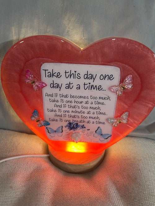 Large maroon resin heart with quote “Take this day one day at a time” with light