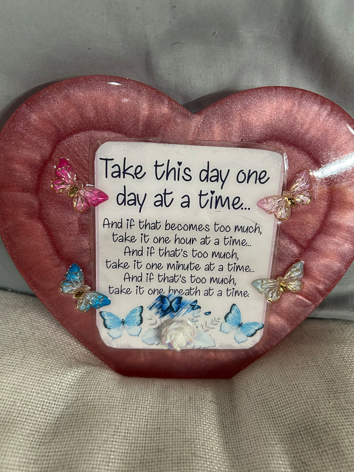 Large maroon resin heart with quote “Take this day one day at a time” with light